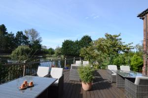 a patio with a table and chairs on a deck at Lakeside Old Hunstanton in Hunstanton
