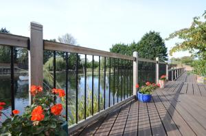 a wooden deck with flowers and a fence at Lakeside Old Hunstanton in Hunstanton