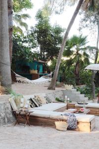a couch sitting on a beach with palm trees at El botanico de Sagra in Sagra