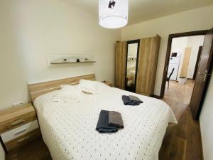 a bedroom with a bed with two black towels on it at Apartmán Sofia in Tale