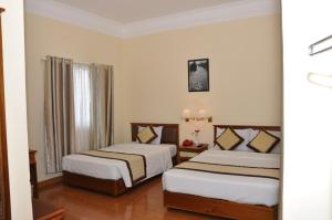 een hotelkamer met 2 bedden en een raam bij Saigon Can Tho Hotel in Can Tho
