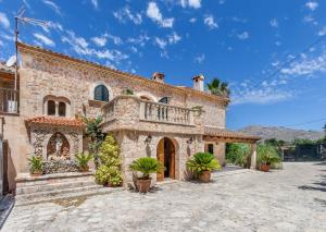 een groot stenen huis met een balkon. bij U Coste en Pollensa in Pollença