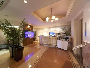 eine Lobby mit einem TV und einer Topfpflanze in der Unterkunft Hotel Fine Rokko Kita Ichibanchi in Kōbe