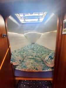ブローニュ・シュル・メールにあるCharmant Voilier chauffé nuit insoliteの小さなお部屋で、ボート内のベッド1台が備わります。