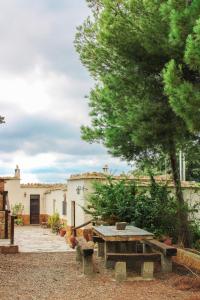 a picnic table in front of a building with a tree at Complejo Rural Rosa del Gamonal in Cádiar