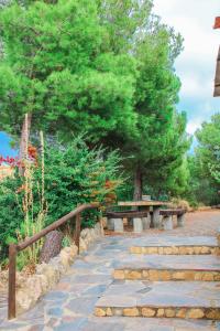 a stone path with benches and trees in a park at Complejo Rural Rosa del Gamonal in Cádiar