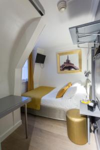 パリにあるプラティック ホテルのベッドとデスクが備わるホテルルームです。