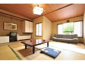 sala de estar con mesa de centro y sofá en Tsubame Highland Lodge燕ハイランドロッジ, en Myoko