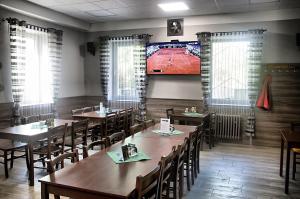 a restaurant with wooden tables and chairs and a tv at Penzion 68 in Kladno
