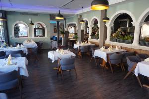 a dining room with white tables and chairs at Bone To in Salzgitter