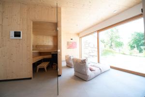 Zimmer mit Sofa, Schreibtisch und Fenster in der Unterkunft Neusach64 in Weissensee