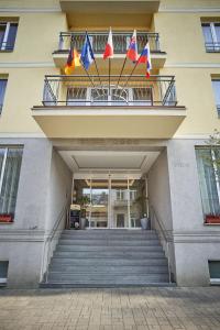 ein Gebäude mit drei Flaggen auf einem Balkon in der Unterkunft Kurhotel Brussel in Franzensbad