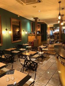 - un restaurant avec des tables et des chaises dans une salle dans l'établissement Grand Hotel Du Calvados, à Paris