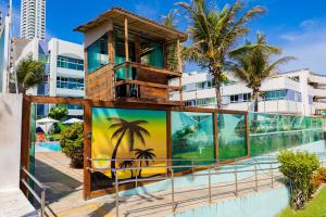un bâtiment avec une fresque murale sur le côté de la piscine dans l'établissement H Ponta Negra Beach, à Natal
