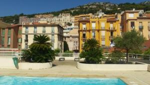 ボーソレイユにあるApartment Monaco Palais Josephineのヤシの木が茂るスイミングプールを併設しています。