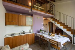 una cocina con mesa, lavabo y escalera en Agriturismo Corte Carezzabella, en San Martino di Venezze