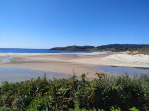 plaża z ludźmi na piasku i wodzie w obiekcie CASA BUITURON w mieście Cee