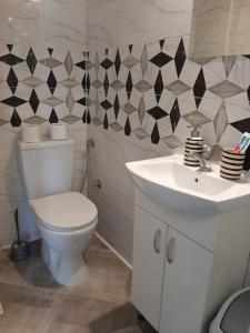 a bathroom with a white toilet and a sink at White City 1 Apartment in Belgrade