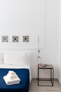 拿坡里的住宿－博格威爾日尼花園住宿加早餐旅館，一间卧室配有一张带蓝色毯子和一张桌子的床。