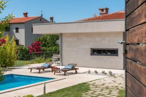 a backyard with a swimming pool and a house at Villa Viviana Fažana Valbandon Heated pool in Fažana