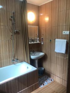 a bathroom with a bath tub and a sink at Casa MIKHA in Sinaia