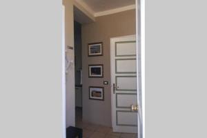 a hallway with a door and pictures on the wall at T Rooms - Appartamento Dafne in Casale Monferrato