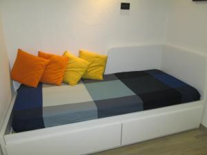 a bed with colorful pillows on it in a room at Cervinia appartamento Pineta in Breuil-Cervinia