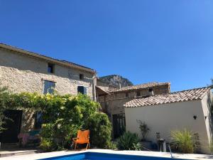 a house with a swimming pool in front of a building at Mas Renard in Beauvoisin