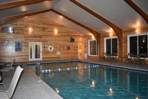a swimming pool in a house with a wooden wall at Lighthouse View Motel in Mackinaw City