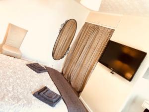a bedroom with a bed and a flat screen tv at AC Lounge 125 in Rochford