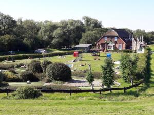 Blick auf einen Park mit einem Haus im Hintergrund in der Unterkunft Ferienwohnung "Sielblick" in Dornumersiel in Dornum