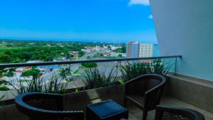 a balcony with two chairs and a view of a city at Holiday Inn Tuxpan - Convention Center, an IHG Hotel in Tuxpan de Rodríguez Cano