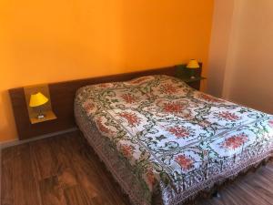 ein Schlafzimmer mit einem Bett mit einer Blumendecke darauf in der Unterkunft La casa dei gerani in SantʼAgata