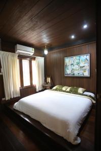 1 dormitorio con 1 cama grande en un barco en Villa Darakorn Hill Country House en Chiang Rai