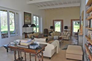 a living room with couches and a table with books at La Bastide rouge in Saint-Geniès-Bellevue