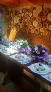 uma mesa longa com pratos de comida e flores em Veselata Guest House em Dolna Banya