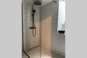 a bathroom with a shower with a glass door at Uccle, Pavillon Vert in Brussels