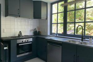 a kitchen with a sink and a stove top oven at Uccle, Pavillon Vert in Brussels