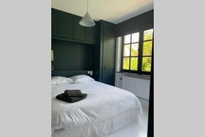 1 dormitorio con cama blanca y ventana en Uccle, Pavillon Vert, en Bruselas