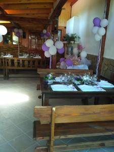 uma sala de jantar com mesas e decorações roxas e brancas em Veselata Guest House em Dolna Banya