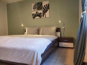 um quarto com uma cama com lençóis brancos e almofadas em Apartment Lavendelgrün em Altenbamberg