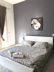 1 dormitorio con 1 cama con una pintura floral en la pared en Glemerald Hostel, en Pula