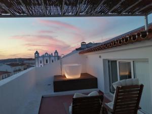 a balcony with a view of a city at sunset at Evora Inn in Évora