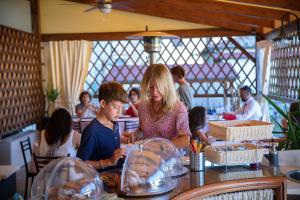 a woman and children sitting at a counter in a restaurant at La Dimora Delle Terme in Rapolano Terme