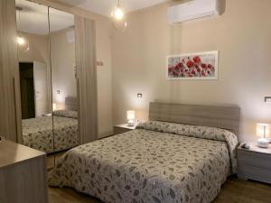 Habitación de hotel con 2 camas y espejo en B&B Il Casale en Foligno