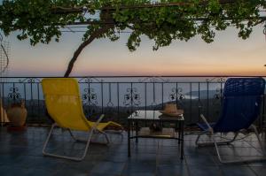two chairs and a table on a balcony with a view at Panorama of Deep Blue in Tséria