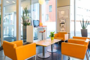 a living room filled with chairs and tables at ibis budget Leuven Centrum in Leuven