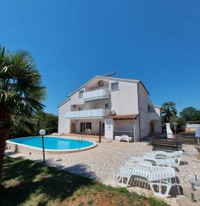 a house with a swimming pool in front of it at Apartments Vila Marinela in Poreč