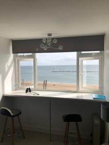 - une fenêtre avec vue sur la plage dans l'établissement Bay View Apartment, à Newbiggin-by-the-Sea