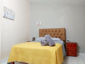 a stuffed animal sitting on a bed with a yellow blanket at Casa Soliman - Cancun Centro Market28 Cable TV HBO FOX Netlix in Cancún